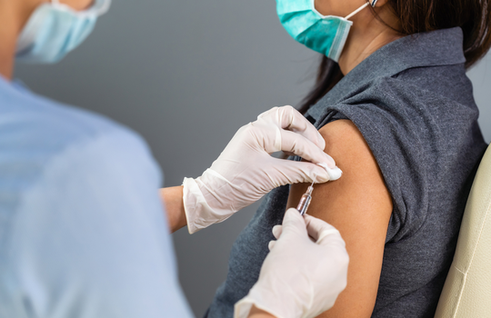Person receiving vaccination from a doctor